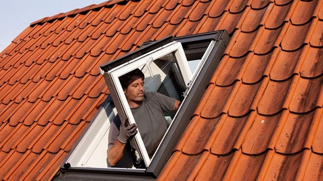 Monteur plaatst een nieuw VELUX dakraam in een pannendak — Dakraam plaatsen all-in: werkzaamheden, inbegrepen en meerwerk