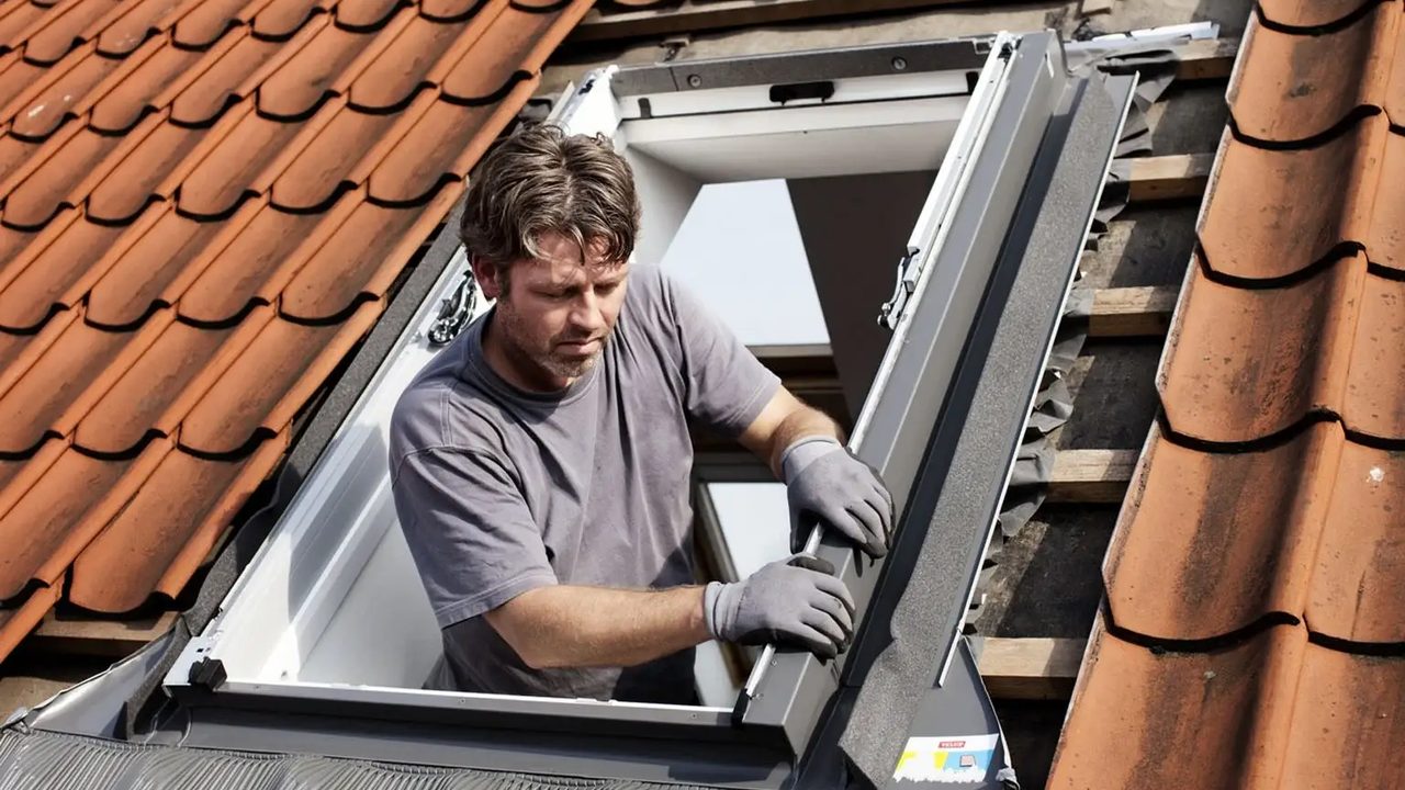 Monteur vervangt een oud dakraam door een nieuw VELUX dakraam — Dakraam vervangen: wanneer is het nodig?