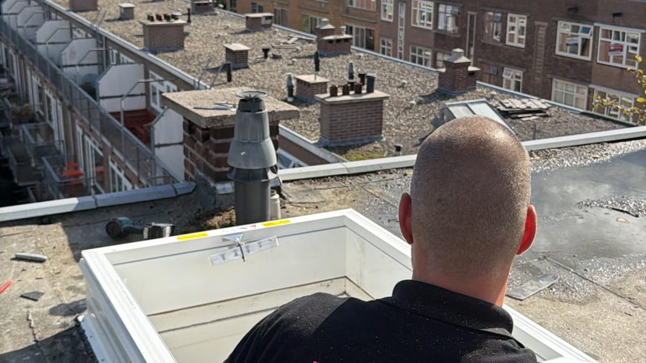 Bouwplaza-monteur bij een lichtkoepel op een plat dak — Lichtkoepel vs. dakraam: welke kiest u?