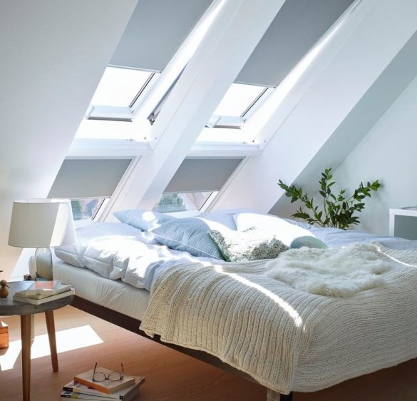 Slaapkamer op zolder met twee VELUX dakramen en lichte raamdecoratie